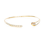 The Cascavel Choker Necklace Petite by Moritz Glik with 1.16ct of diamonds set and enclosed in a Kaleidoscope Shaker™ in 18k gold. Featuring a diamond-filled, oval Kaleidoscope Shaker™ on one side, counterbalanced by seven bezel-set round and oval diamonds, all set in an open-front, asymmetrical frame. Angled to the right.