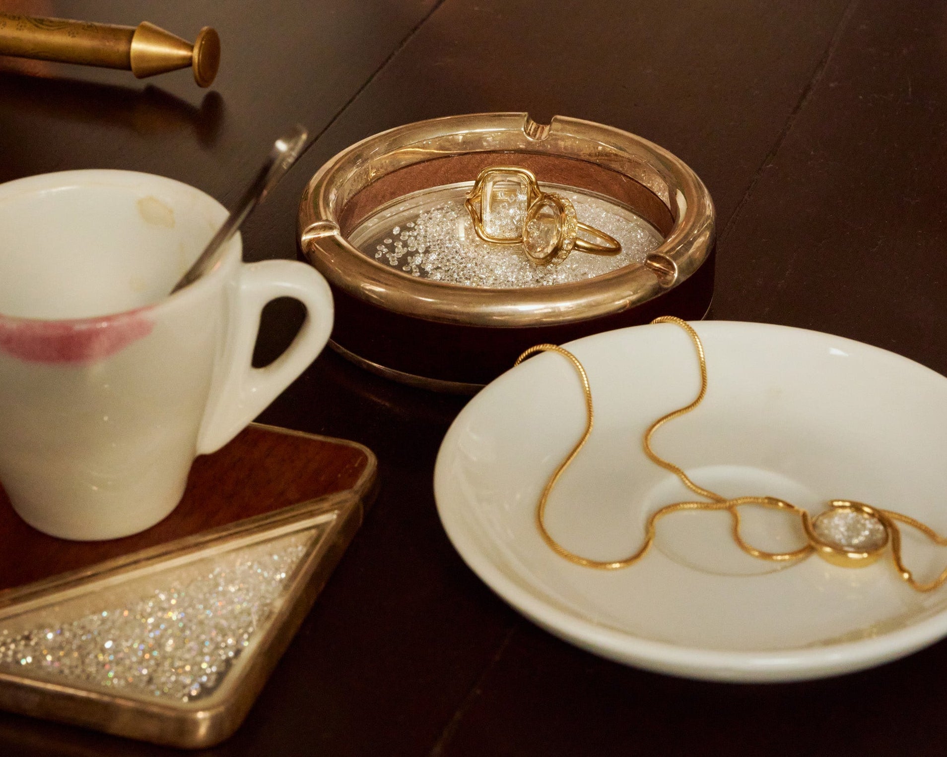 Shaker Jewelry on decorative plates with a cup and small container on a wooden surface