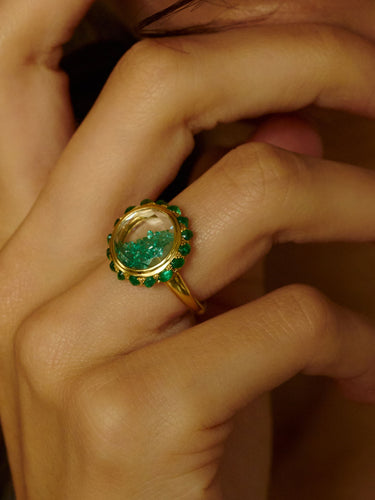 Close-up of a hand wearing a the Antique 12 Ring with emeralds by Moritz Glik.