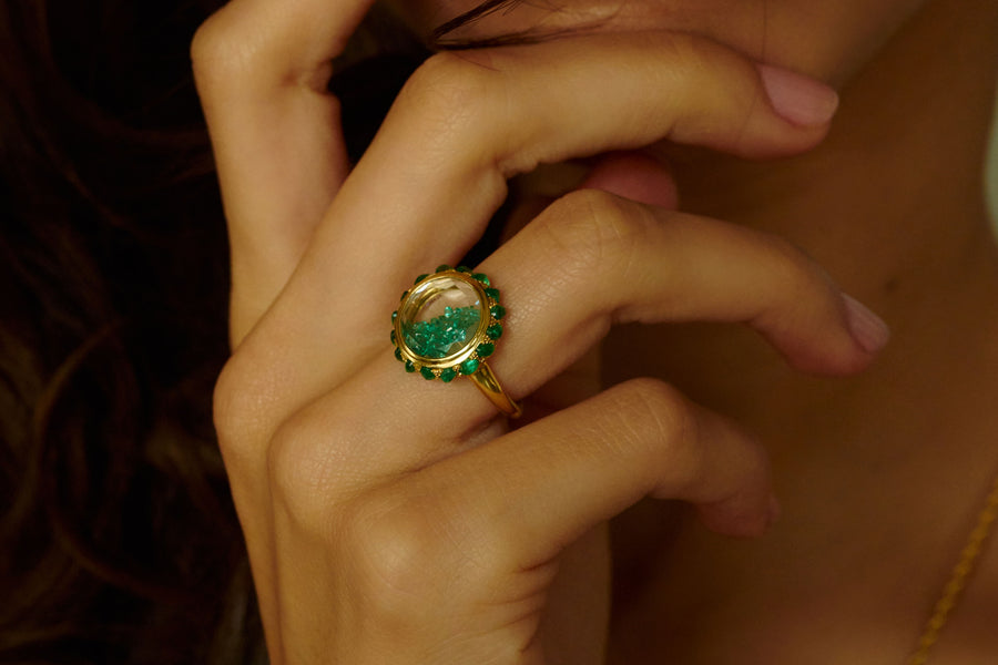 Close-up of a hand wearing a the Antique 12 Ring with emeralds by Moritz Glik.